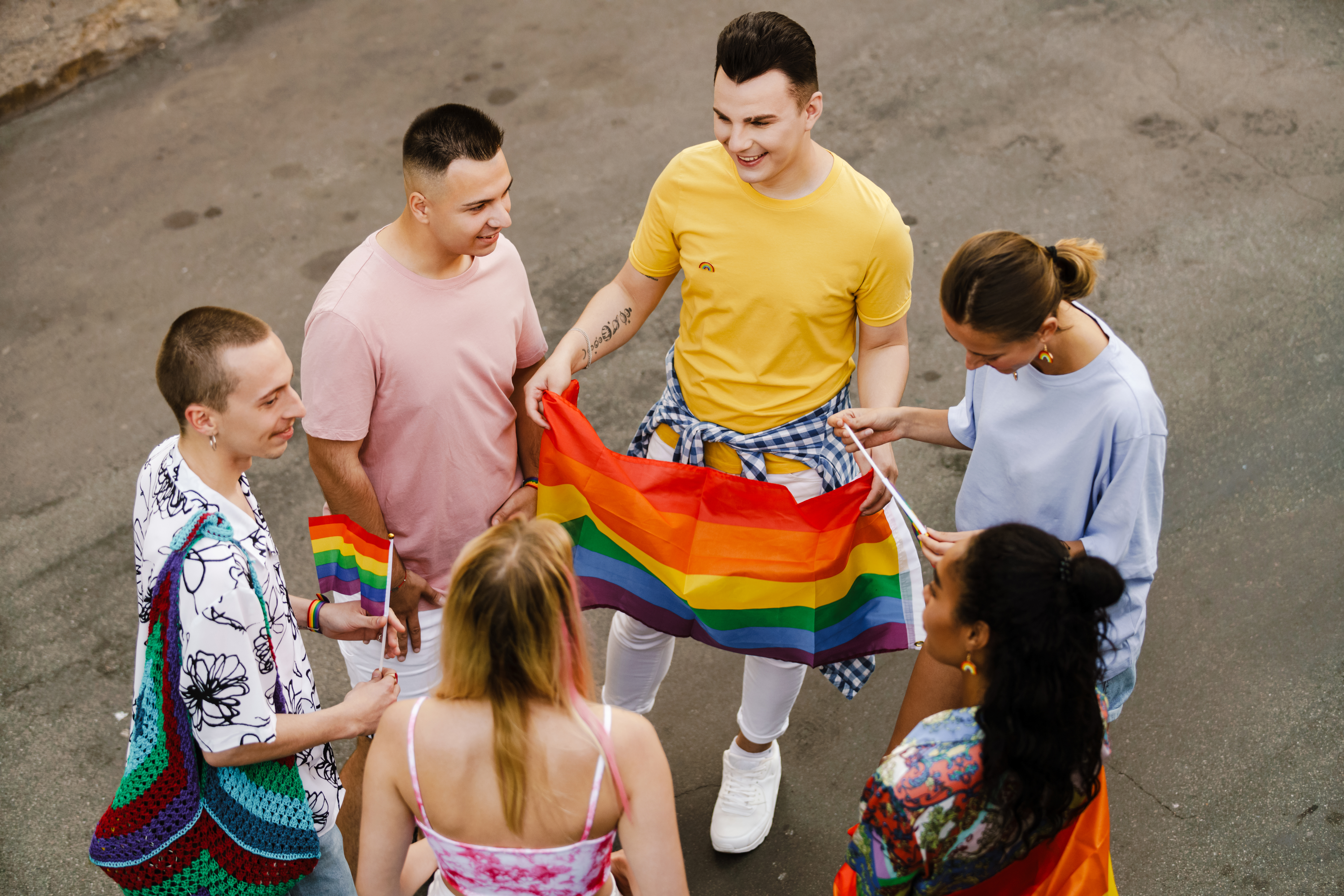 Giovani che festeggiano con bandiere arcobaleno a un evento pride
