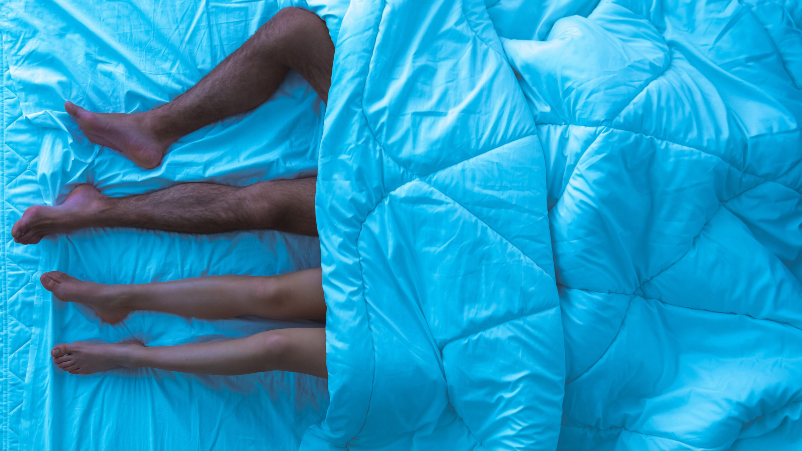 The couple sleeping under the duvet. evening night time. view from above